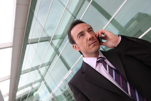 Affärsman med hjälp av en mobiltelefon i staden — Stockfoto