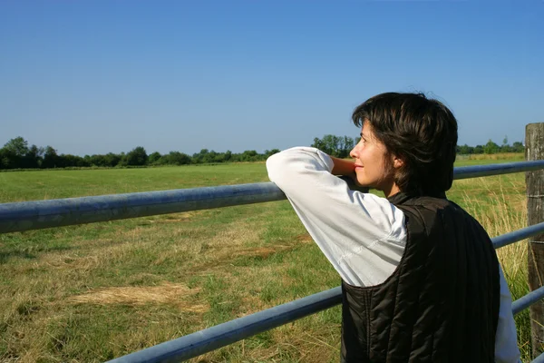 Female farmer stood looking at her land — Stock Photo, Image