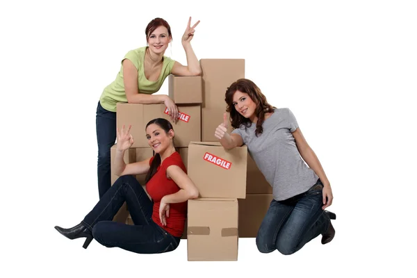 Drie vrouwen verzameld door kartonnen dozen — Stockfoto