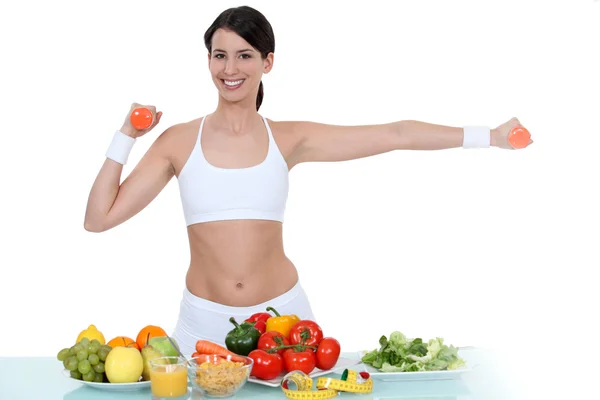Femme en tenue de gym se tenait avec des légumes — Photo