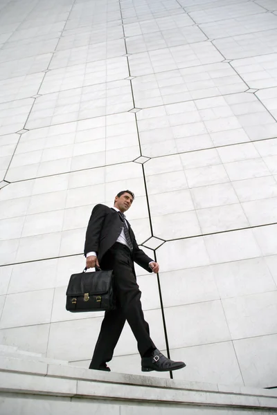 Бизнесмен с портфелем спускается по лестнице — стоковое фото