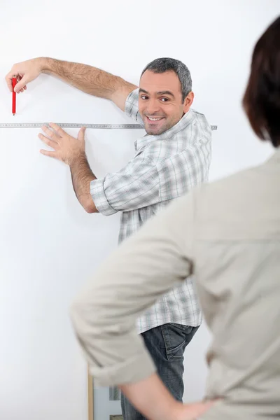 Manžel, přičemž měření v domě — Stock fotografie