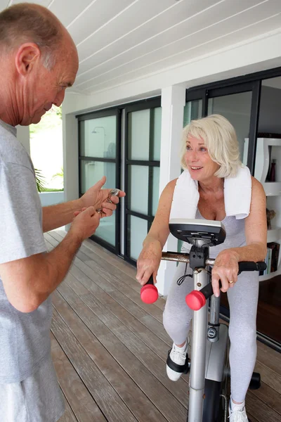 Man timing his wife's workout — Stock Photo, Image