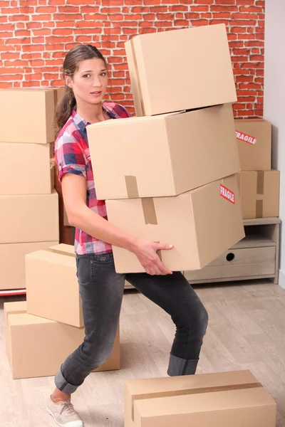 Woman struggling to carry boxes — Stock Photo, Image