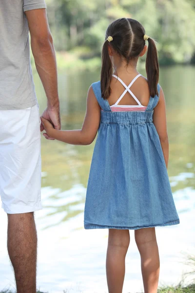 Батько і дочка тримаються за руки — стокове фото