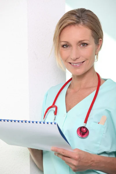 Kvinnlig sjuksköterska med pappersarbete — Stockfoto