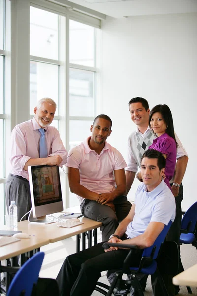Ομάδα συναδέλφων που συγκεντρώθηκαν γύρω από υπολογιστή — Φωτογραφία Αρχείου