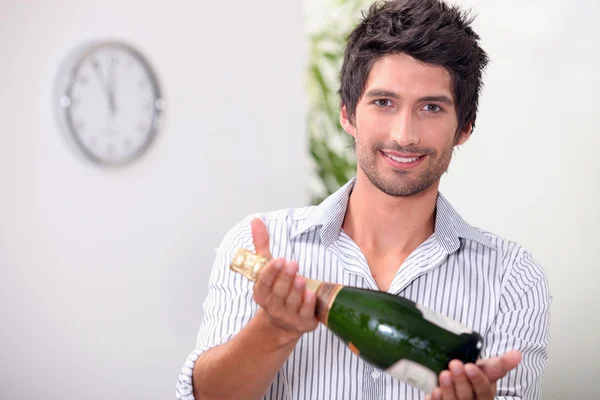 Man offering a bottle of champagne at five minutes to midnight — Stock Photo, Image