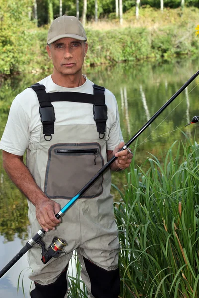 Homem pesca na lagoa — Fotografia de Stock