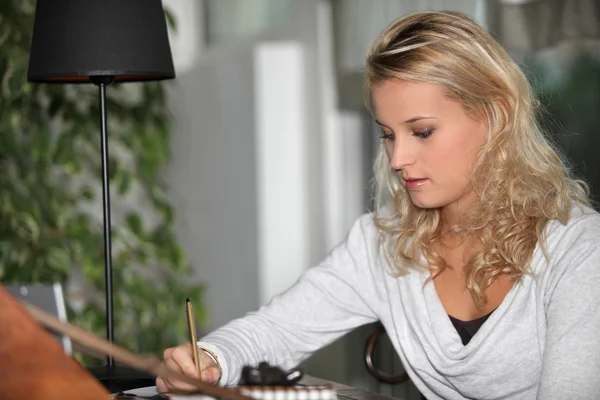 Молодая женщина студентка делает домашнее задание — стоковое фото
