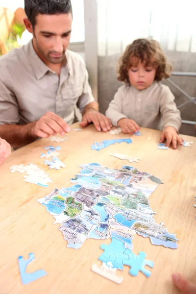 Father and son doing jigsaw puzzle — Stock Photo, Image