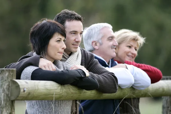 Due coppie appoggiate su un recinto di campagna — Foto Stock