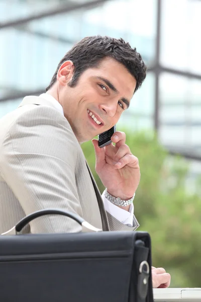 Affärsman med hjälp av en mobiltelefon utanför — Stockfoto