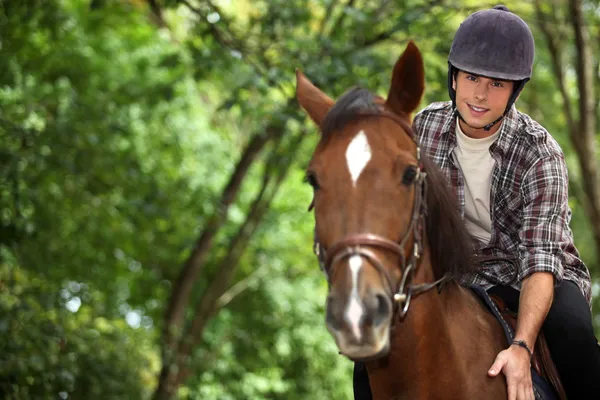 Mladý muž na koni koně — Stock fotografie