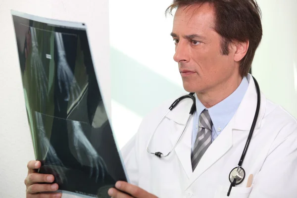 Arzt beobachtet Hand-Röntgen — Stockfoto