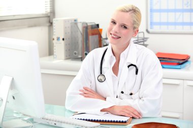 Doctor sitting behind her desk clipart