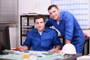 Two technicians working in office clipart