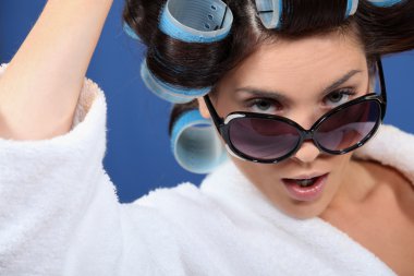 Woman wearing sunglasses and hair rollers clipart