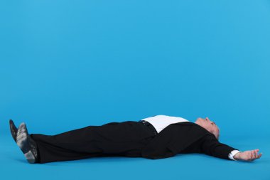 Businessman laying on floor clipart