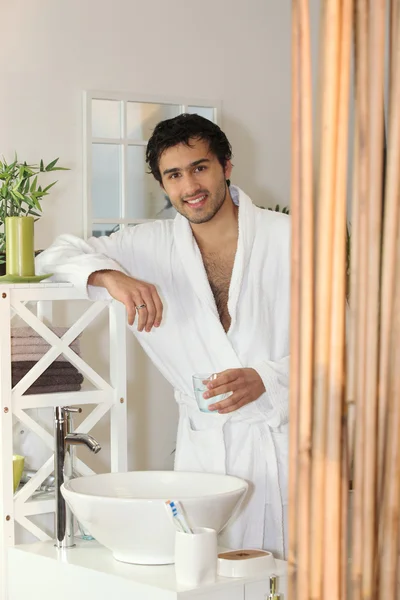 Man dricker ett glas vatten i hans badrum — Stockfoto