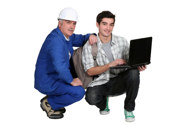 A tradesman helping his apprentice write a report of his experience — Stock Photo, Image