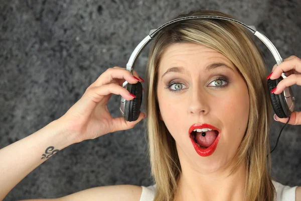 Здивована жінка слухає музику — стокове фото