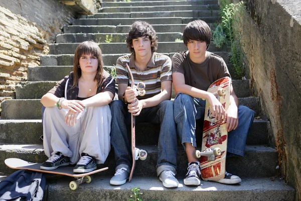 Trzy nastolatki skaterzy usiadł na kroki — Zdjęcie stockowe