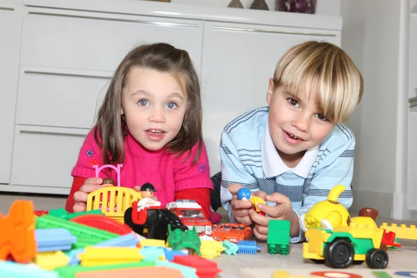 Irmão e irmã brincando com brinquedos — Fotografia de Stock