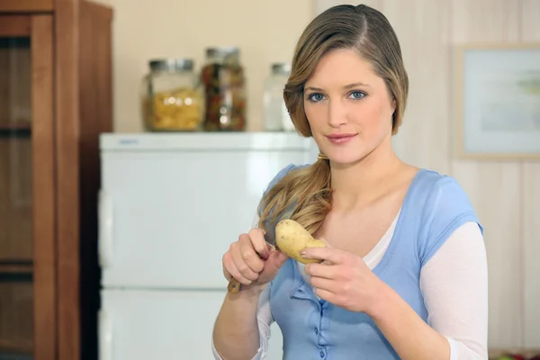Жінка ріже картоплю — стокове фото