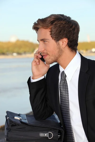 Młody człowiek rozmawia przez telefon na zewnątrz — Zdjęcie stockowe