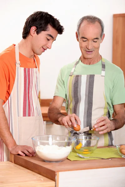 Senior and junior cooking together — Stock Photo, Image