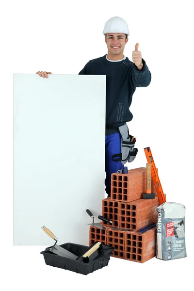 Polegares para cima de um construtor com uma placa em branco — Fotografia de Stock
