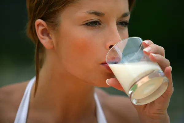 Brünette trinkt Glas Milch — Stockfoto