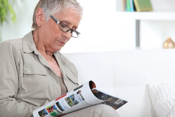 Mulher idosa leitura revista — Fotografia de Stock