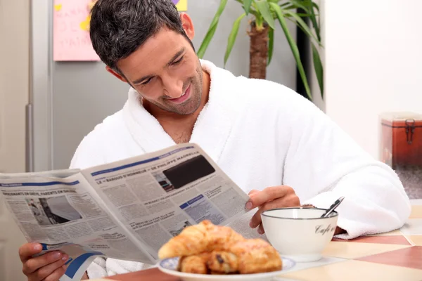 Homem na mesa da cozinha tomando café da manhã — Fotografia de Stock