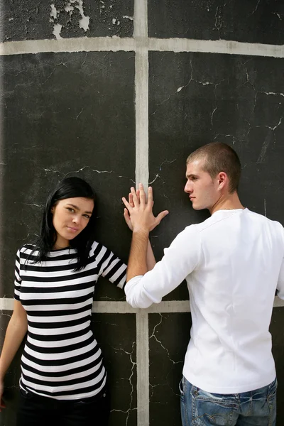 Affectionate couple stood by wall — Stock Photo, Image