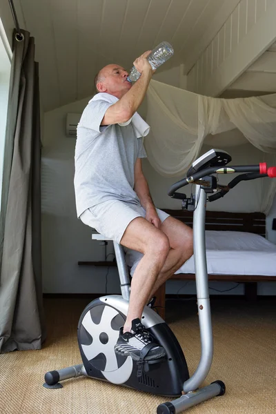 Homme âgé faisant de l'exercice avec une bouteille d'eau — Photo
