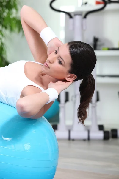 Kvinnan gör sit-ups på gym boll — Stockfoto