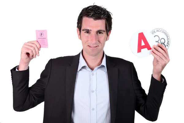 Mannen i kostym visar franska körkort och klistermärken för ung förare — Stockfoto