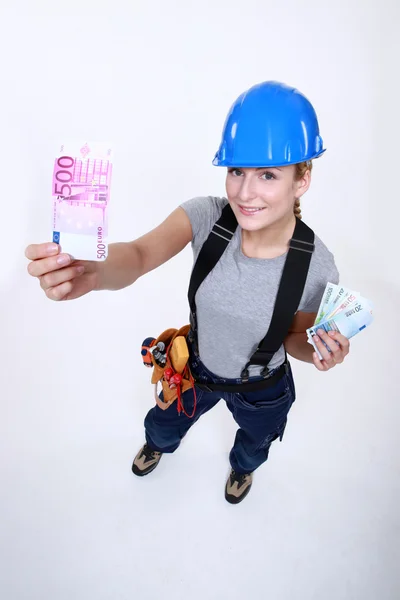 Female electrician holding money — Stock Photo, Image
