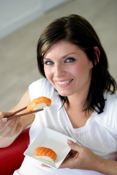 Brunetka jíst chutné shushi — Stock fotografie