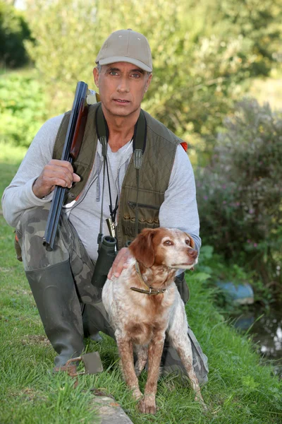 Hunter ajoelhado por cão — Fotografia de Stock