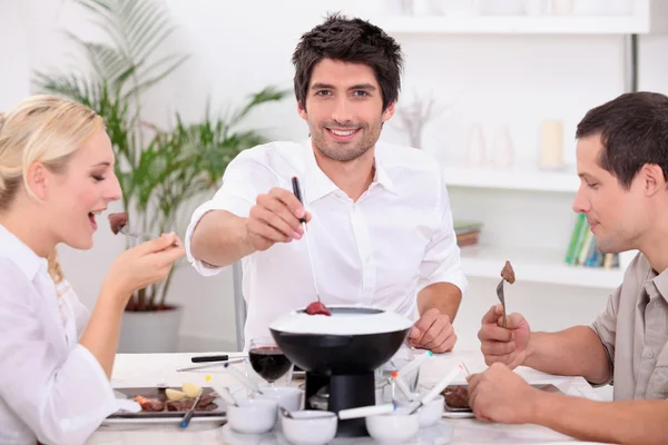 Vänner njuter av choklad fondue — Stockfoto