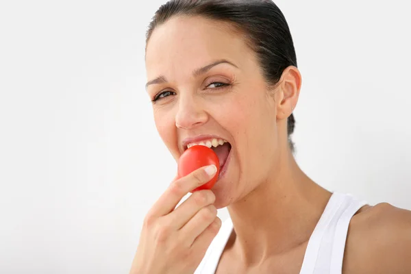 Frau isst eine Tomate — Stockfoto