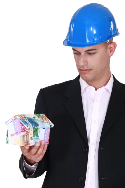 Architect holding house made from euro bank notes — Stock Photo, Image