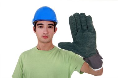 Young tradesman wearing an oversized glove clipart