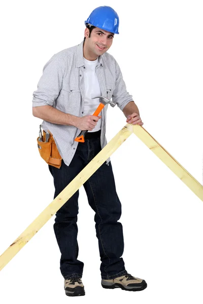Carpenter nailing a frame — Stock Photo, Image
