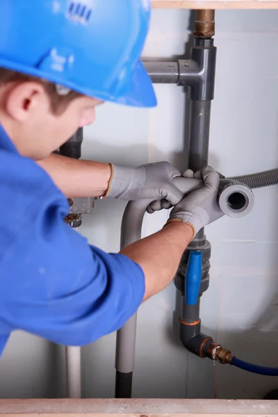 Plombier installant des tuyaux d'eau domestiques en plastique — Photo