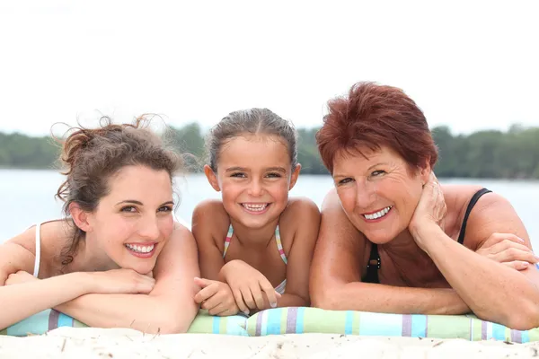 A 30 years old woman, a little girl and a 55 years old woman lying down on — Stock Photo, Image