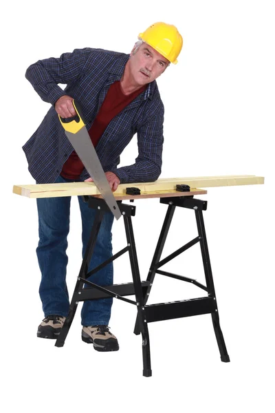 Handwerker sägt eine Holzplanke — Stockfoto